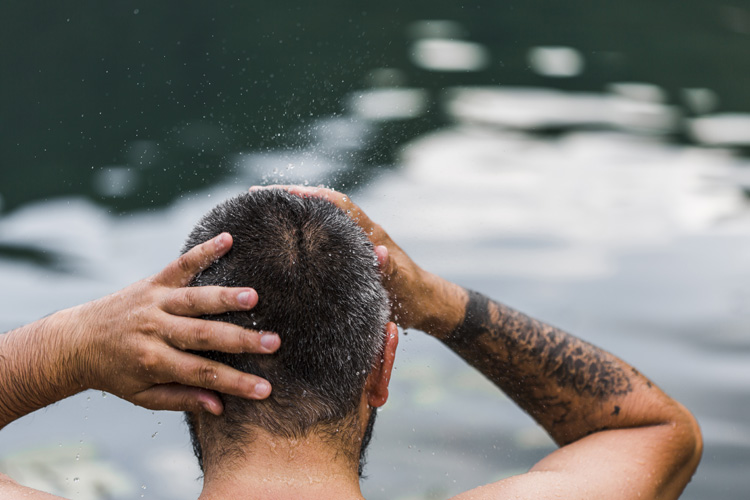 Bild zeigt Mann im Wasser mit nassen Haaren im Winter