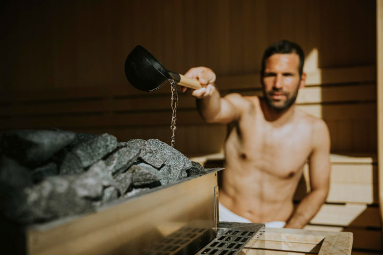 Mann macht Aufguss in Sauna